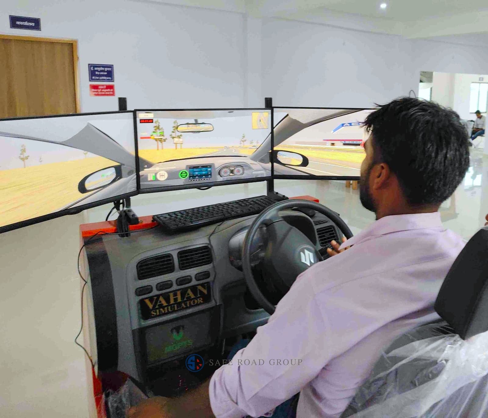 A trainee at the light vehicle simulator, the road running on the screens