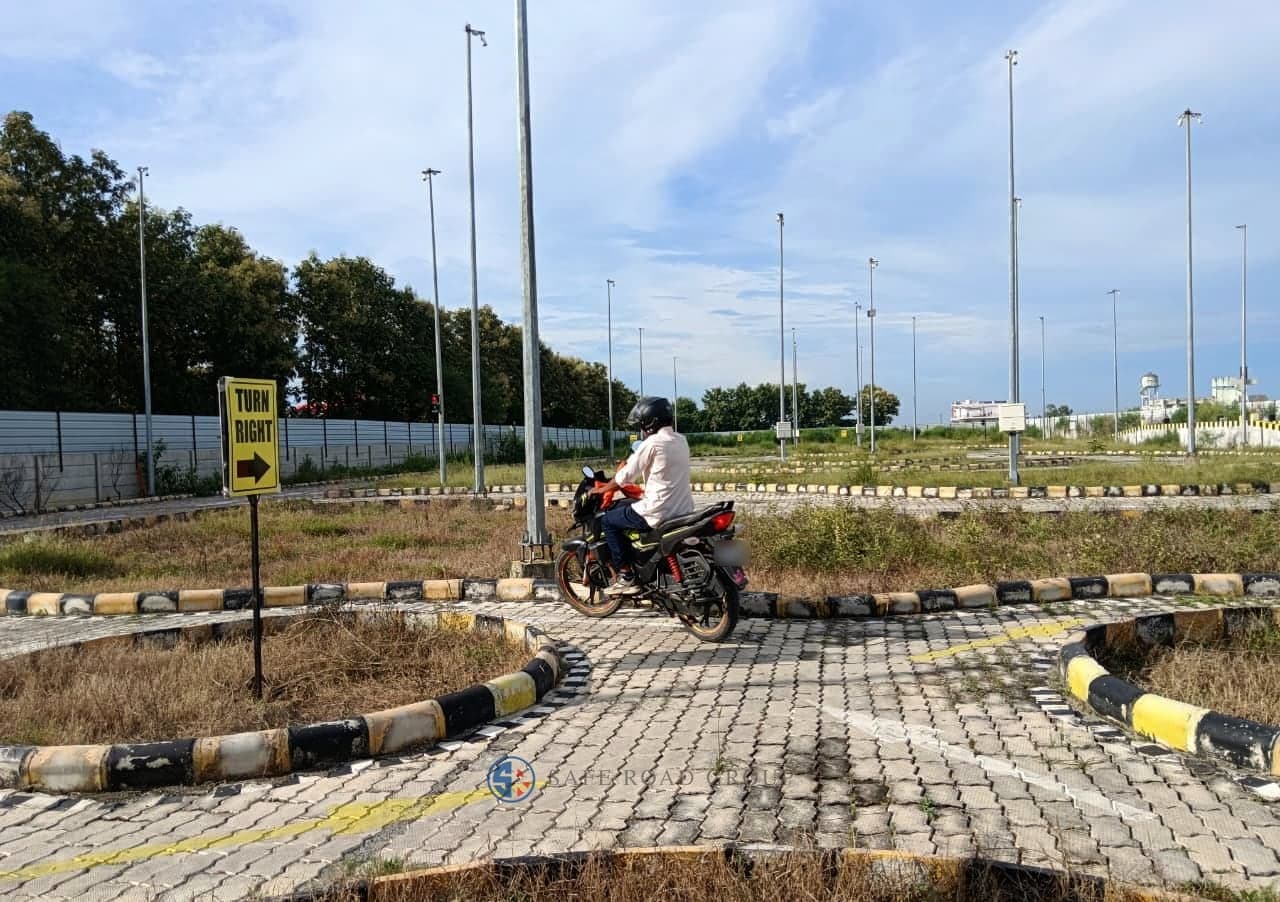 A rider taking the two-wheeler test on the circuit, helmeted